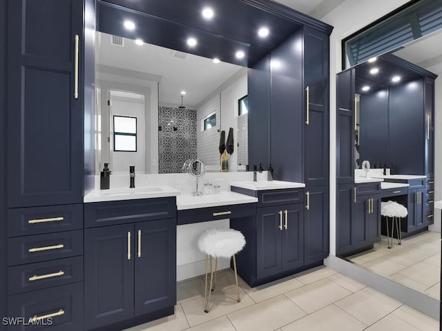 bathroom with tile patterned flooring, vanity, and walk in shower