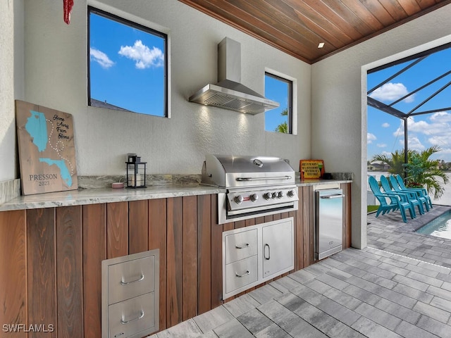 kitchen featuring ornamental molding, fridge, wall chimney range hood, and wood ceiling