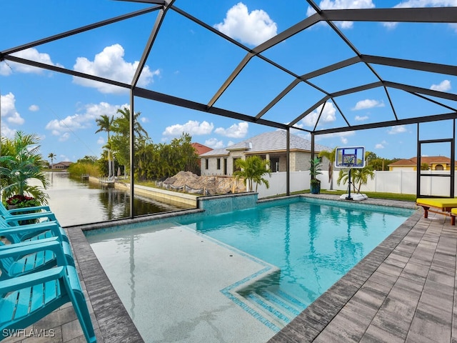 view of pool with a water view, glass enclosure, and a patio area