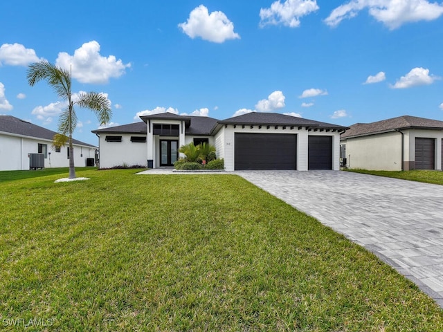 prairie-style home with a garage, cooling unit, and a front lawn