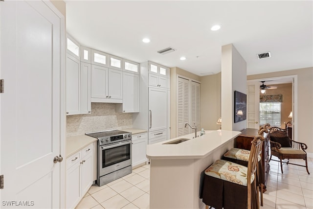 kitchen featuring white cabinetry, stainless steel electric range oven, tasteful backsplash, and sink