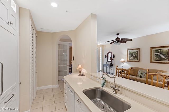 kitchen with ceiling fan, dishwasher, sink, white cabinetry, and light tile patterned floors