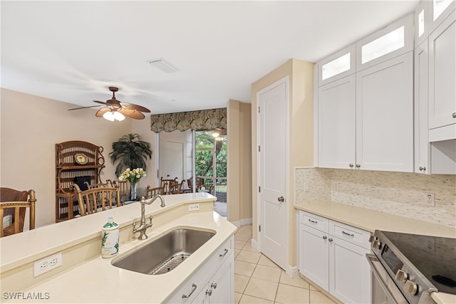 kitchen featuring electric stove, light tile patterned floors, white cabinets, and sink