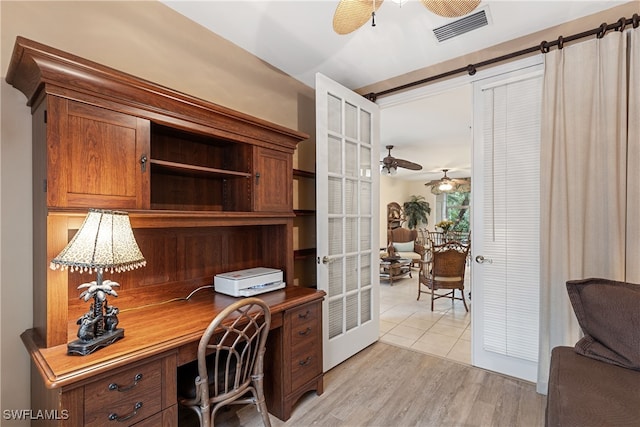 home office with ceiling fan, light hardwood / wood-style floors, and french doors