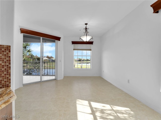 unfurnished room featuring light tile patterned flooring and a water view