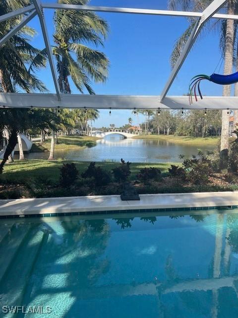 view of swimming pool featuring a water view and a lanai