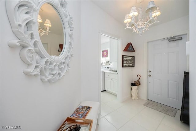 interior space with vanity, washer / clothes dryer, tile patterned flooring, and a notable chandelier