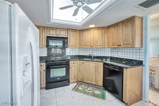 kitchen with dark stone counters, sink, decorative backsplash, and black appliances