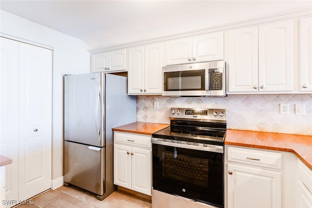 kitchen featuring white cabinetry, backsplash, stainless steel appliances, and light tile patterned flooring