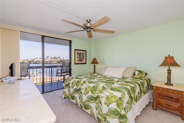 carpeted bedroom with expansive windows, ceiling fan, and access to outside