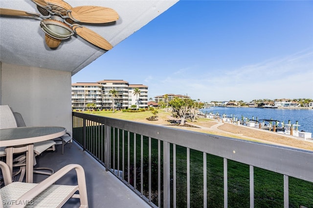 balcony featuring a water view and ceiling fan