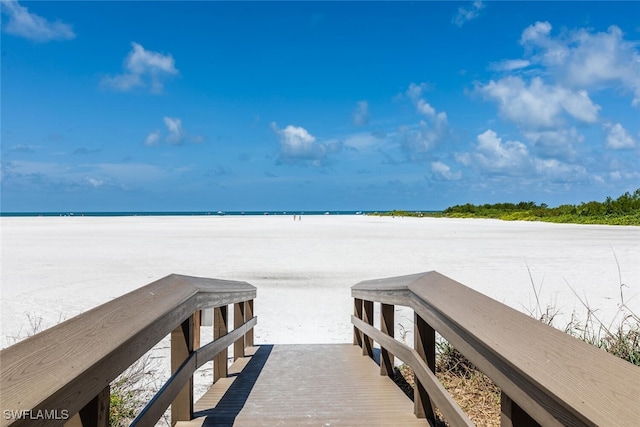 view of dock featuring a water view and a view of the beach