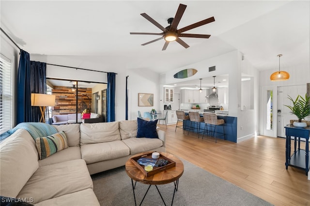 living room with vaulted ceiling, hardwood / wood-style floors, and ceiling fan