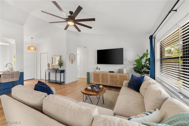 living room featuring light hardwood / wood-style flooring, sink, vaulted ceiling, and ceiling fan