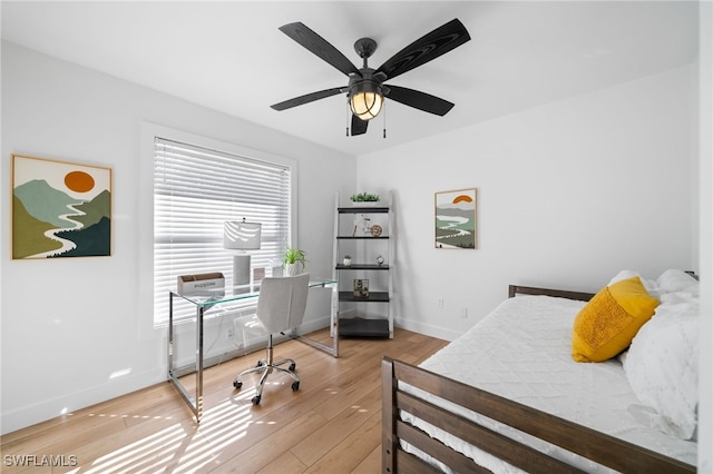 bedroom featuring multiple windows, light hardwood / wood-style flooring, and ceiling fan