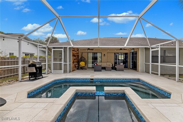 view of pool with an in ground hot tub, ceiling fan, a lanai, and a patio