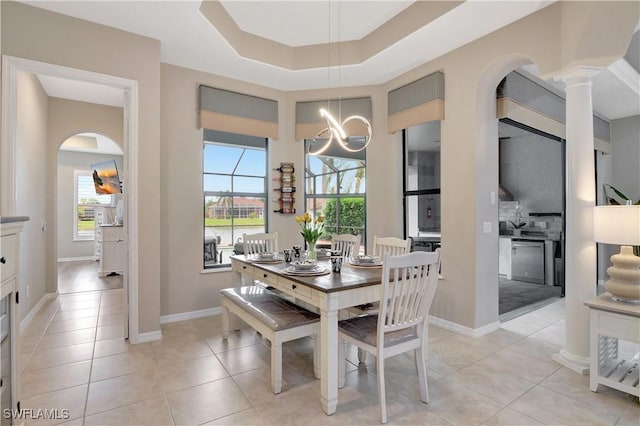 tiled dining space featuring a tray ceiling