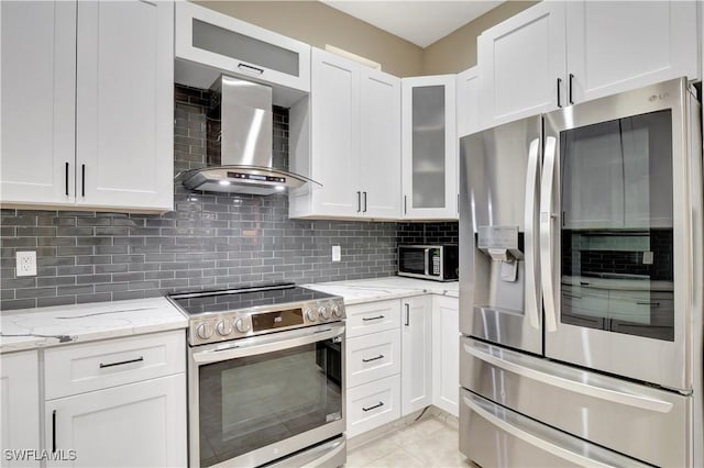 kitchen featuring wall chimney exhaust hood, stainless steel appliances, and white cabinetry