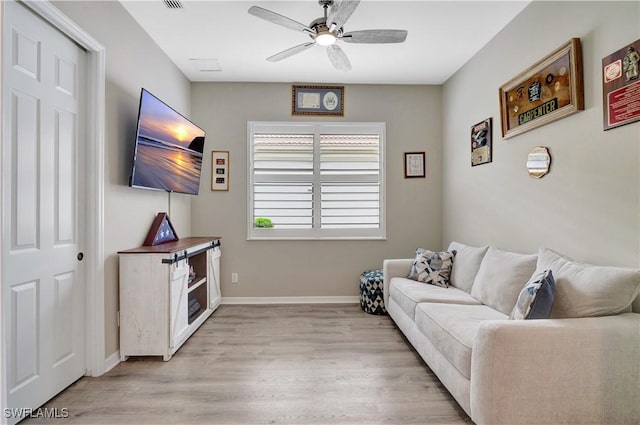 living room with ceiling fan and light hardwood / wood-style floors