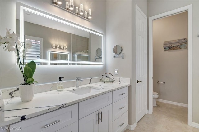 bathroom with toilet, tile patterned floors, and vanity