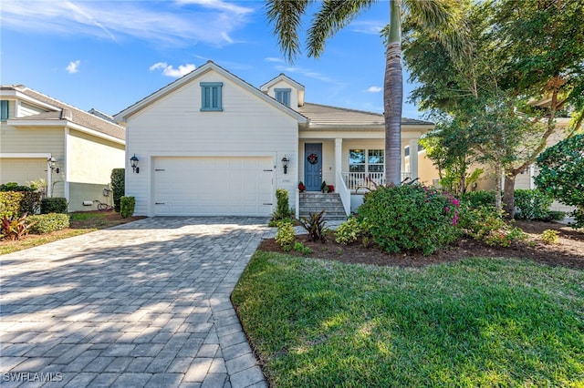 view of front of home with a porch, a garage, and a front lawn