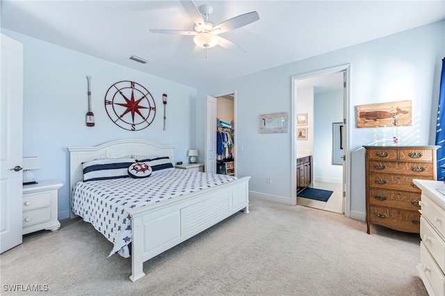 carpeted bedroom with ceiling fan, a walk in closet, ensuite bath, and a closet