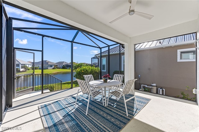 sunroom featuring a water view and ceiling fan