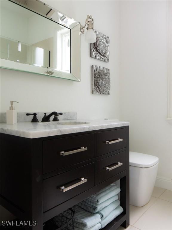 bathroom with toilet, vanity, and tile patterned flooring