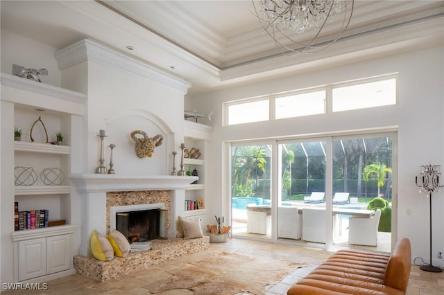 living room featuring a premium fireplace, crown molding, built in features, and a towering ceiling