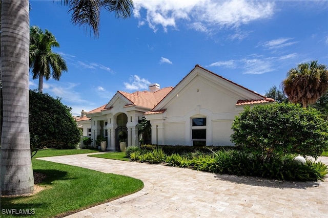 mediterranean / spanish house with a front yard