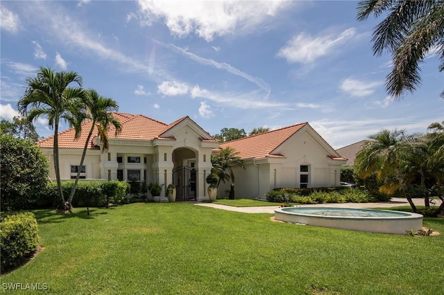 mediterranean / spanish-style house featuring a front lawn