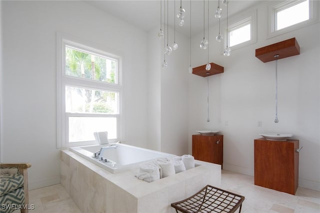 bathroom with tiled tub and vanity