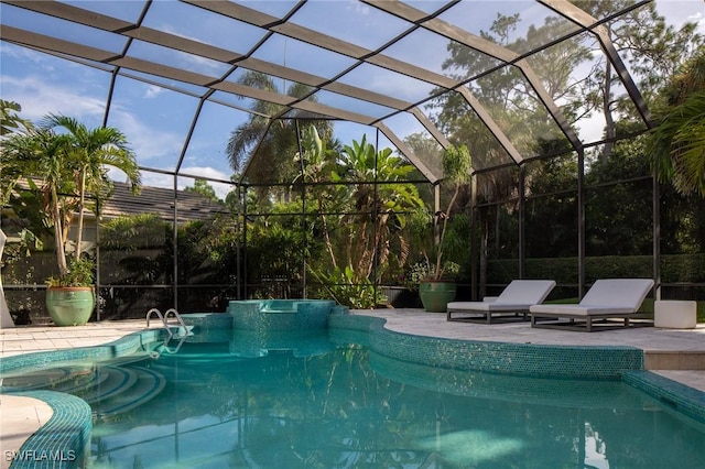 view of pool with glass enclosure and a patio