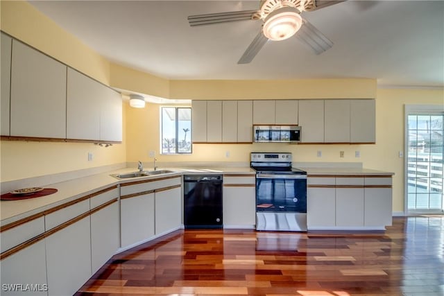 kitchen featuring stainless steel appliances, white cabinetry, sink, and dark hardwood / wood-style floors