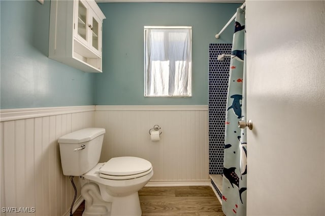 bathroom featuring toilet, wood-type flooring, and walk in shower