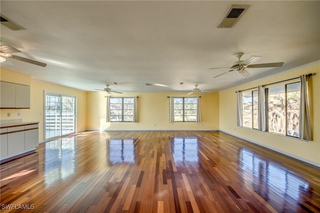 unfurnished living room with hardwood / wood-style flooring, ceiling fan, and plenty of natural light