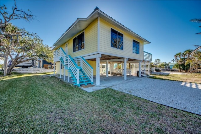 back of property with a carport and a yard