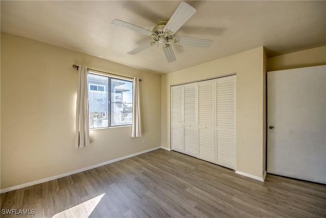 unfurnished bedroom featuring light hardwood / wood-style flooring, a closet, and ceiling fan