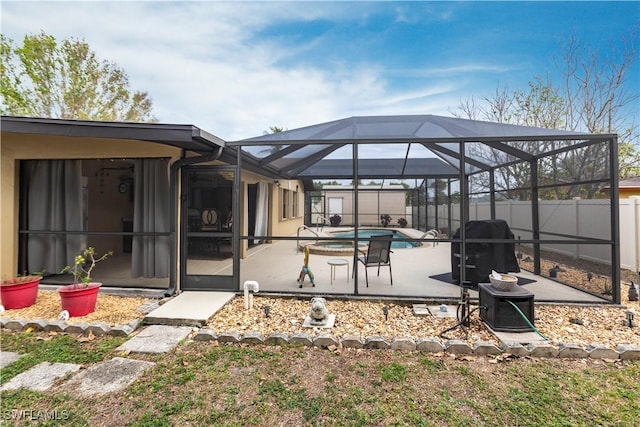 view of patio / terrace featuring a lanai, a swimming pool with hot tub, and area for grilling