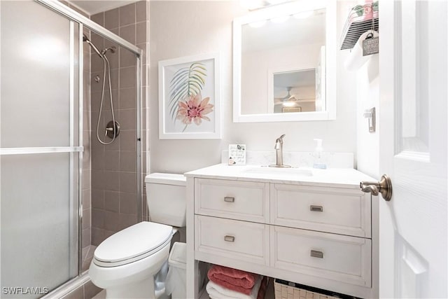 bathroom featuring toilet, vanity, and an enclosed shower