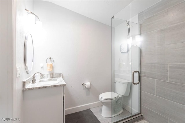 bathroom featuring a shower with shower door, vanity, and toilet