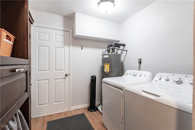 laundry room with washer and clothes dryer, water heater, and light wood-type flooring