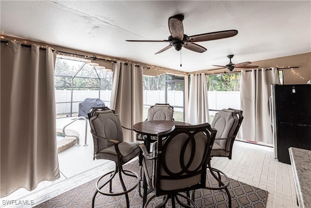 dining area featuring ceiling fan, plenty of natural light, and a textured ceiling