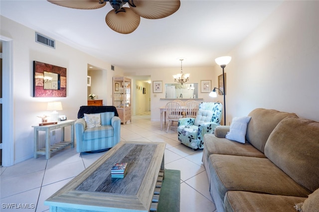 living room featuring light tile patterned flooring and ceiling fan with notable chandelier