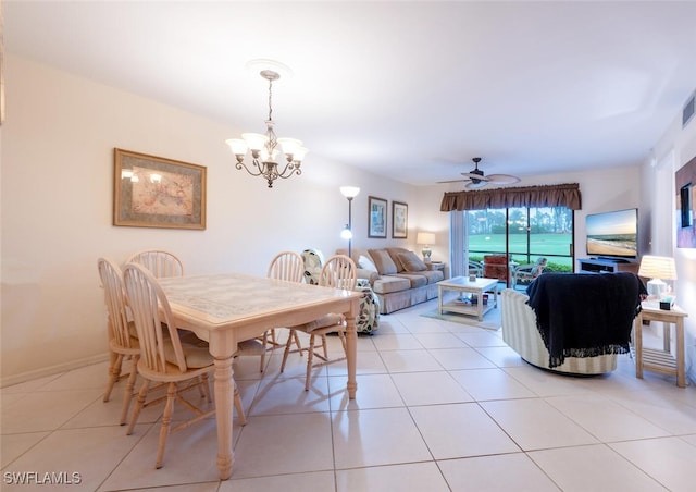 tiled dining room featuring ceiling fan with notable chandelier