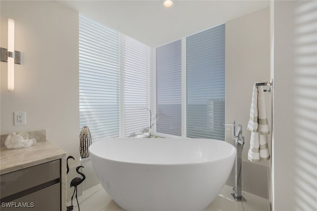 bathroom with a soaking tub and vanity