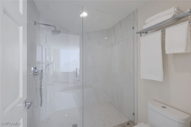 full bathroom with a marble finish shower and toilet