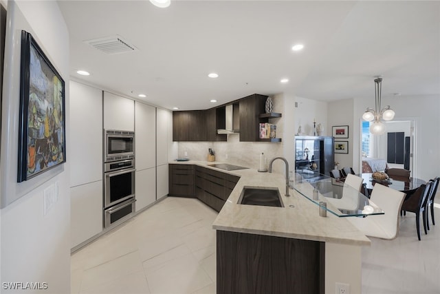 kitchen featuring black electric cooktop, a peninsula, a sink, open shelves, and stainless steel microwave