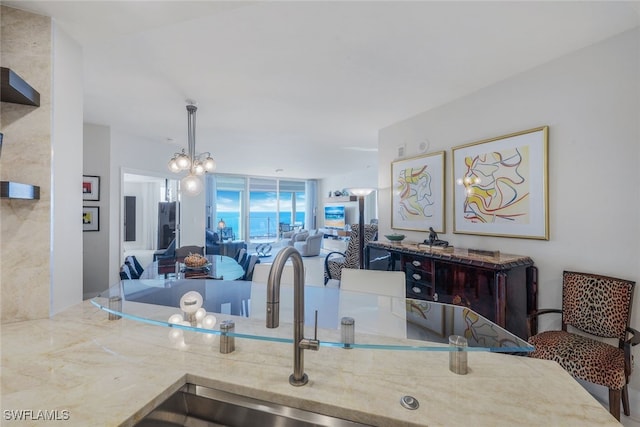 kitchen with open floor plan, light countertops, a sink, and decorative light fixtures