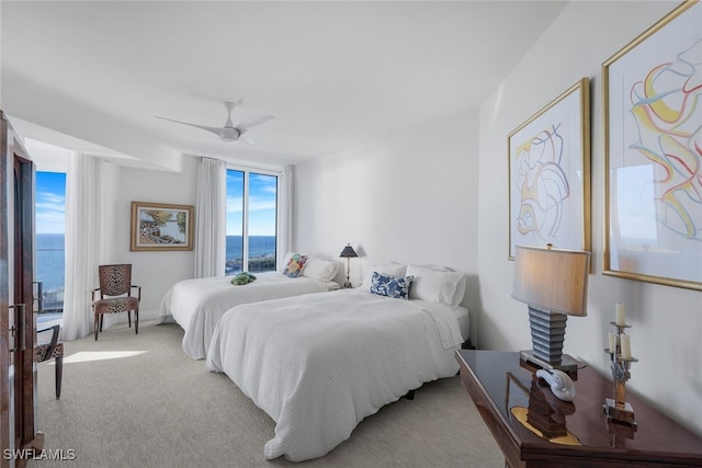 bedroom featuring carpet, a water view, and ceiling fan